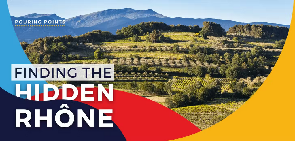 Napa Valley Wine Academy Wine Articles and Podcasts A green field with trees, mountains in the background, and a red and blue sign with white text in the foreground.