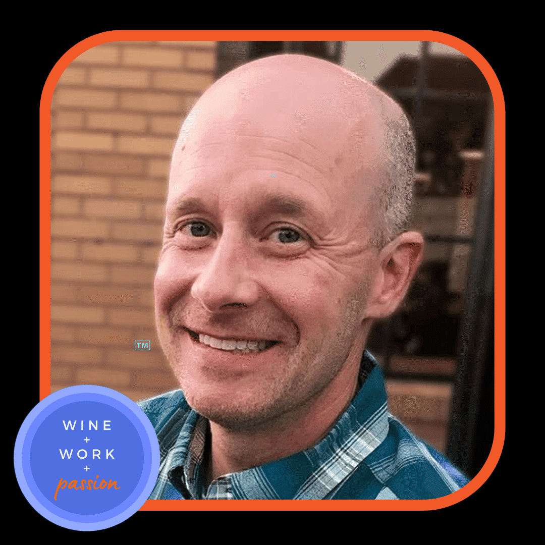 Napa Valley Wine Academy Wine Articles and Podcast  A man smiling directly at the camera, showcasing his face prominently with a visible blue circle featuring white text in the background.