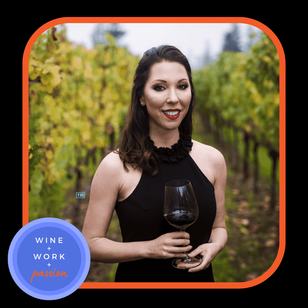 Napa Valley Wine Academy Wine Articles and Podcast A woman smiling at the camera while holding a glass of wine, with a close-up of her neck and black ruffle detail.