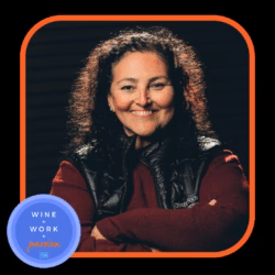 A woman with curly hair smiling, wearing casual clothing; a blue circle with white text visible in the background.