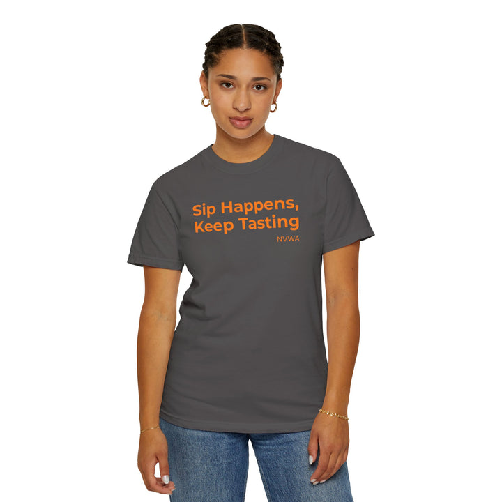 Woman in NVWA T-shirt Sip Happens, Keep Tasting with orange text, showcasing casual style and relaxed fit, perfect for wine enthusiasts.