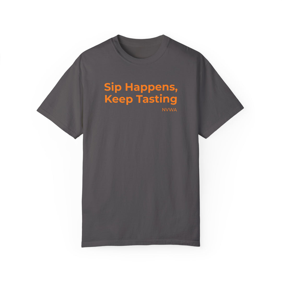 NVWA T-shirt “Sip Happens, Keep Tasting” features orange text on a grey background, perfect for wine enthusiasts, offering comfort with its relaxed fit and durable stitching.