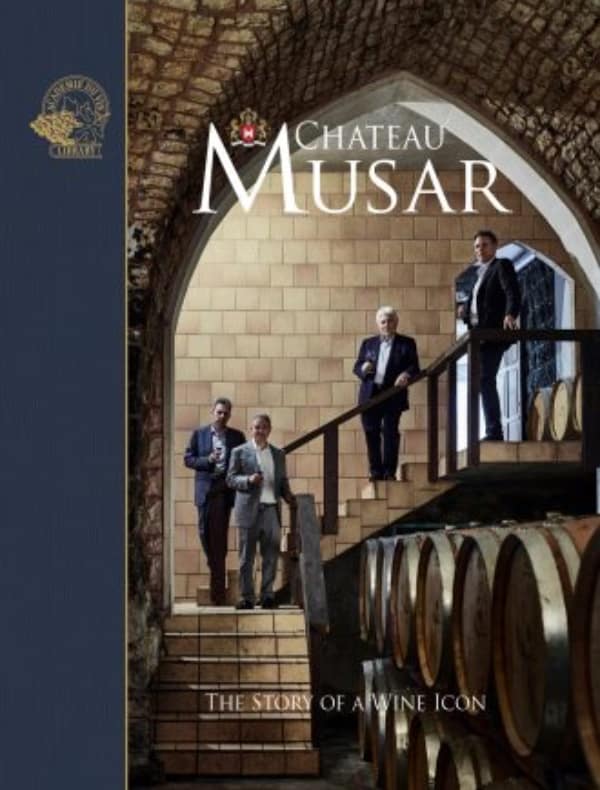 Men walking down stairs with wine barrels at Chateau Musar winery, highlighting the legacy of Lebanese winemaker Serge Hochar and the winery's rich history.