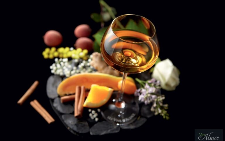 wine glass surrounded by fruit and flowers on table